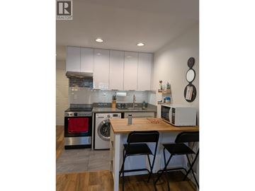 Burnaby apartment for rent - A modern kitchen with a wooden table and chairs.