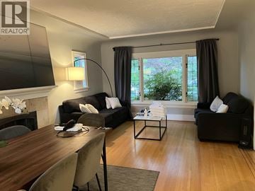 Vancouver apartment for rent - A living room with a wooden table and two black couches.