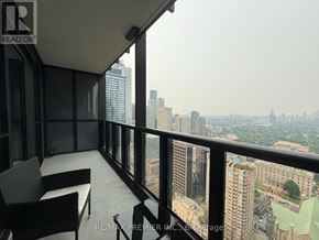 Toronto (Church-Yonge Corridor) condo for rent - A balcony with chairs and a table overlooking a cityscape.
