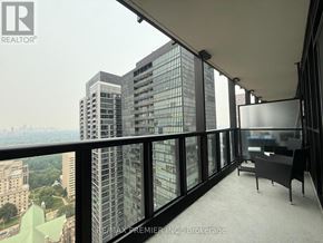 Toronto (Church-Yonge Corridor) condo for rent - A balcony with a table and chairs overlooking a cityscape.