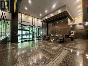 Toronto (Church-Yonge Corridor) condo for rent - A lobby with a large marble floor and a glass wall.