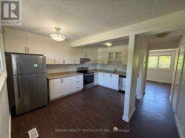 Kitchener townhouse for rent - A kitchen with white cabinets and a stainless steel refrigerator.