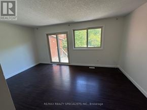 Kitchener townhouse for rent - A room with a sliding glass door leading to a backyard.