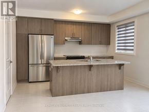 Halton Hills (Georgetown) townhouse for rent - A kitchen with a refrigerator, sink, and cabinets.