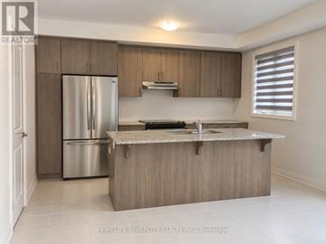 Halton Hills (Georgetown) townhouse for rent - A kitchen with a refrigerator, sink, and cabinets.