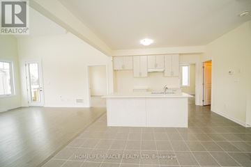 Loyalist (Bath) apartment for rent - A spacious, empty room with a kitchen area in the middle.