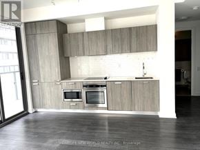 Toronto (Church-Yonge Corridor) condo for rent - A modern kitchen with wooden cabinets and stainless steel appliances.