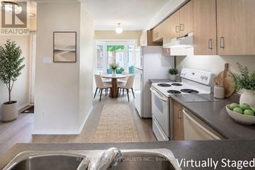 Mississauga (Central Erin Mills) townhouse for rent - A kitchen with a stove top oven and a dining table with chairs.