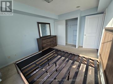 Toronto (Malvern) condo for rent - A bedroom with a bed made of wooden slats.