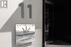 Toronto (Waterfront Communities) condo for rent - A real estate sign for 11 Charlotte Street is displayed on a building.
