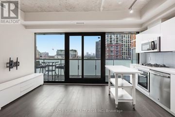 Toronto (Waterfront Communities) condo for rent - A modern kitchen with white cabinets and a view of the city.