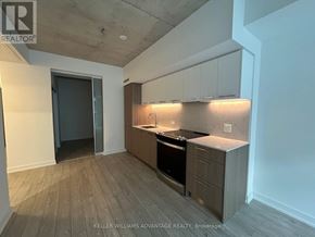 Toronto (South Riverdale) condo for rent - A modern kitchen with wooden floors and white walls.