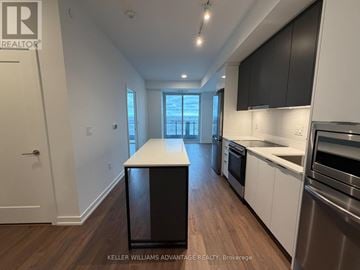 Markham (Greensborough) condo for rent - A kitchen with a black island in the middle of the room.