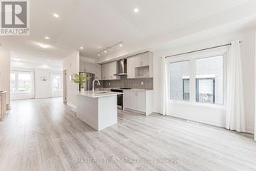 Whitchurch-Stouffville (Stouffville) townhouse for rent - A spacious kitchen with a white island and modern appliances.