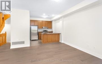 Oakville (Wm Westmount) townhouse for rent - A spacious kitchen with wooden cabinets and a white refrigerator.