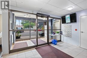 Windsor condo for rent - The image shows the entrance to a realtor's office with a glass door and a sign on the wall.