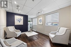 Windsor condo for rent - A realtor's office with white furniture and a blue accent wall.