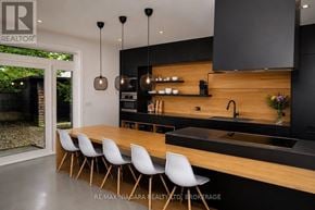 St. Catharines (Lakeport) apartment for rent - A modern kitchen with a long wooden island and white chairs.