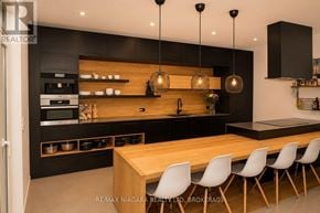 St. Catharines (Lakeport) apartment for rent - A modern kitchen with a wooden table and white chairs.