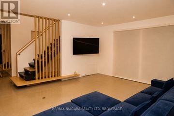 St. Catharines (Lakeport) apartment for rent - A living room with a television and a staircase.