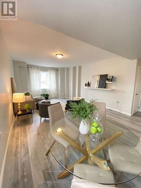 Barrie (Letitia Heights) multi-family for rent - A modern living room with a glass table and white chairs.