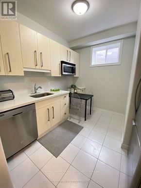 Barrie (Letitia Heights) multi-family for rent - A kitchen with white cabinets and a microwave above the stove.