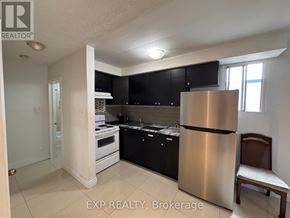 Mississauga (Port Credit) multi-family for rent - A kitchen with black cabinets and a stainless steel refrigerator.