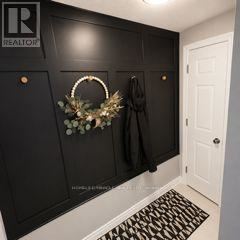 Guelph (Grange Road) apartment for rent - A black door with a wreath and a coat hanging on it.