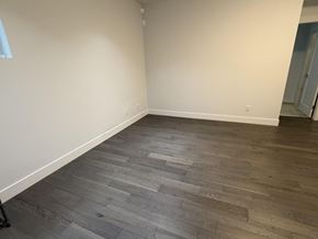 Surrey apartment for rent - A room with wooden flooring and white walls.