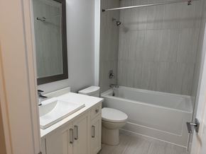 Surrey apartment for rent - A white bathroom with a toilet, sink, and bathtub.