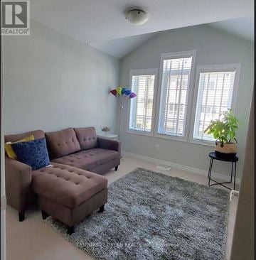 Cambridge townhouse for rent - A living room with a brown couch and a grey rug.