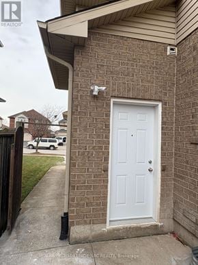 Hamilton (Stoney Creek) multi-family for rent - A white door is on a brick house.