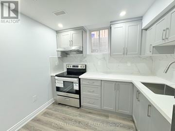 Hamilton (Stoney Creek) multi-family for rent - A kitchen with white cabinets and a stainless steel oven.