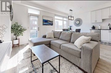 Vaughan (Vaughan Grove) townhouse for rent - A modern living room with a grey sofa and a black coffee table.