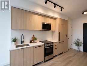 Toronto (Centennial Scarborough) condo for rent - A modern kitchen with wooden cabinets and stainless steel appliances.