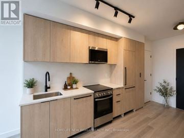 Toronto (Centennial Scarborough) condo for rent - A modern kitchen with wooden cabinets and stainless steel appliances.