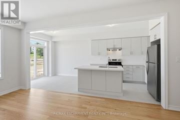 Brant (Paris) townhouse for rent - A white kitchen with a refrigerator on the right side.