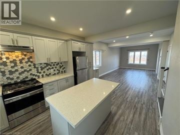 Niagara Falls house for rent - A kitchen with a stove top oven and a refrigerator.