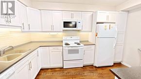 London East (East F) condo for rent - A kitchen with white appliances and cabinets.