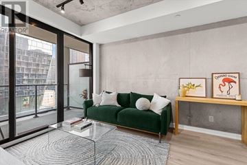 Toronto (Moss Park) condo for rent - A living room with a green couch and a glass table.