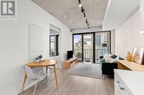 Toronto (Moss Park) condo for rent - A well-lit, modern living room with a dining table and chairs.