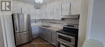 Toronto (Henry Farm) condo for rent - A kitchen with white cabinets and a stainless steel refrigerator.