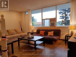 Toronto (Henry Farm) condo for rent - A living room with a brown couch, a coffee table, and a lamp.