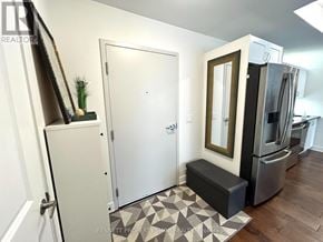 Ottawa condo for rent - A kitchen with a white door, a black fridge, and a black and white tiled floor.