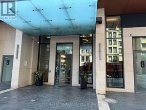 Toronto (North St. James Town) condo for rent - The image shows the front of a building with a glass door entrance and a sign that reads REALTOR.