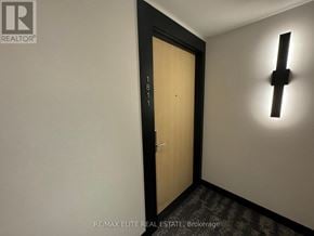 Toronto (North St. James Town) condo for rent - A door with the number 1811 on it is in a room with a black frame and a black light on the wall.