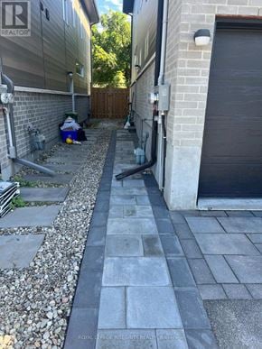 Ottawa apartment for rent - A grey paved walkway leads from a driveway to a garage.