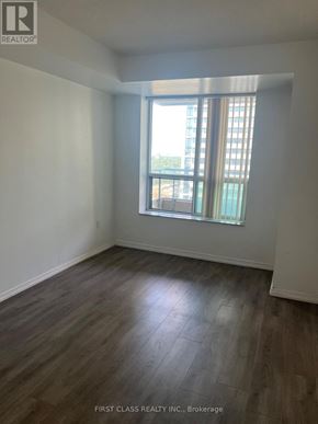 Toronto (Newtonbrook East) condo for rent - A room with wooden flooring and a window with a view of a building outside.