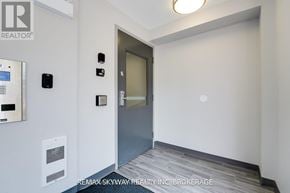 Waterloo condo for rent - A hallway with a door and a wall-mounted device.