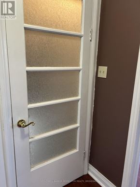 St. Catharines (Fairview) duplex for rent - A white door with a gold handle is open to a room with brown walls.